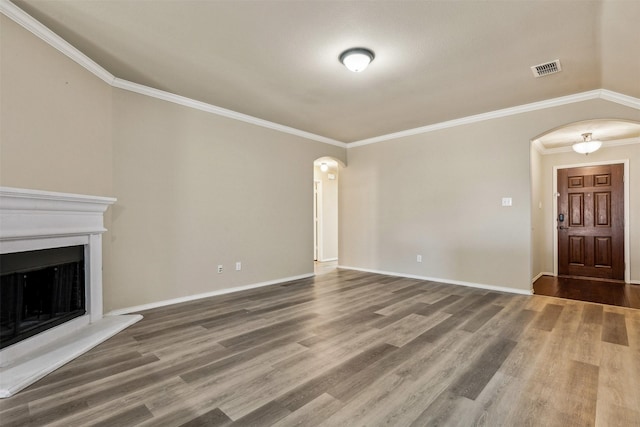 unfurnished living room featuring hardwood / wood-style flooring and ornamental molding