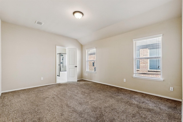 empty room featuring lofted ceiling and carpet floors