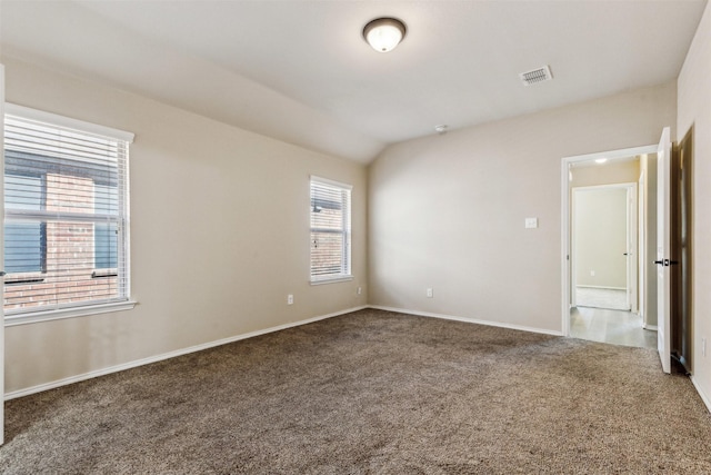 carpeted spare room with vaulted ceiling