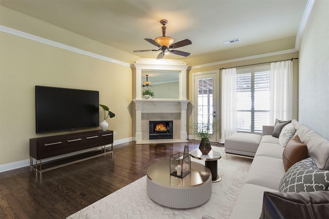 living room featuring wood-type flooring, ornamental molding, ceiling fan, and a fireplace