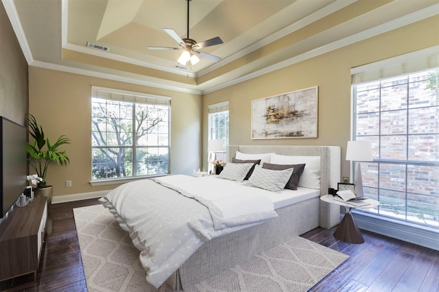 bedroom with crown molding, ceiling fan, dark hardwood / wood-style floors, and a raised ceiling