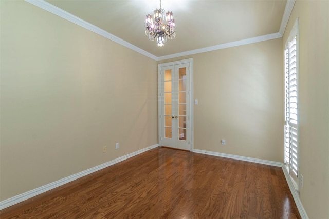 unfurnished room featuring wood-type flooring, ornamental molding, an inviting chandelier, and french doors