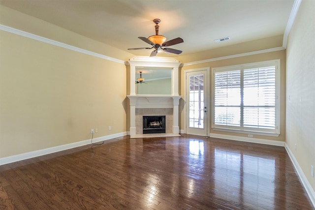 unfurnished living room featuring a tile fireplace, ornamental molding, ceiling fan, and dark hardwood / wood-style flooring