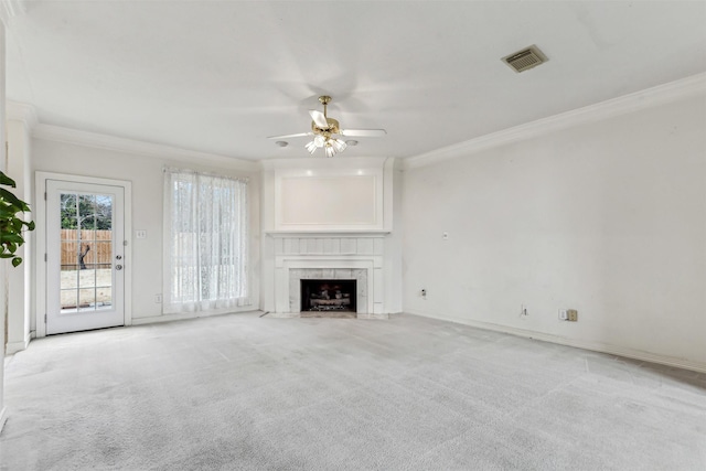 unfurnished living room with ceiling fan, light colored carpet, ornamental molding, and a premium fireplace