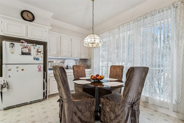 dining area with ornamental molding and a chandelier