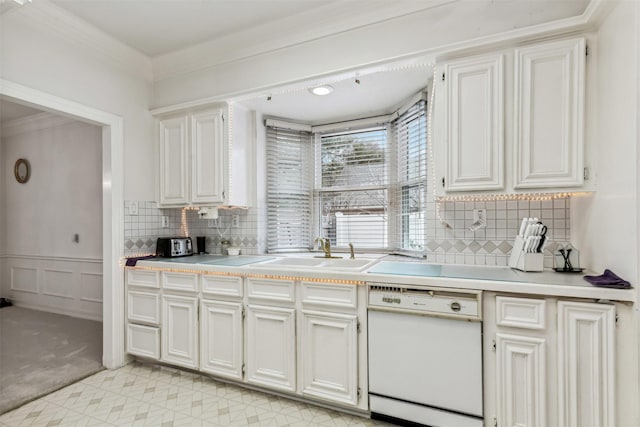 kitchen with ornamental molding, white dishwasher, sink, and white cabinets