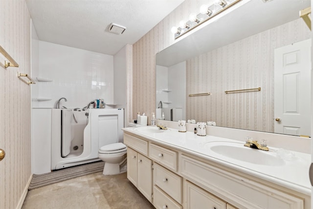 bathroom featuring vanity, a textured ceiling, and toilet