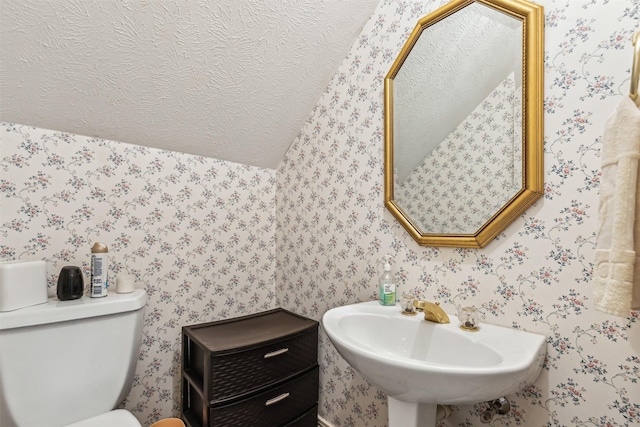 bathroom with toilet, sink, and a textured ceiling