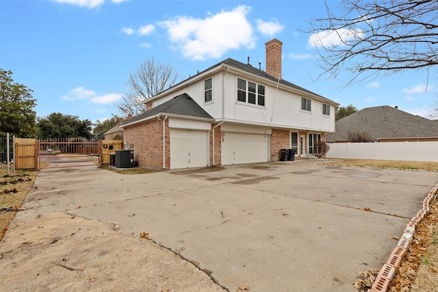 back of house featuring cooling unit and a garage