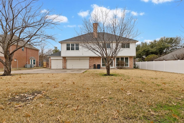 back of property featuring a garage and a yard