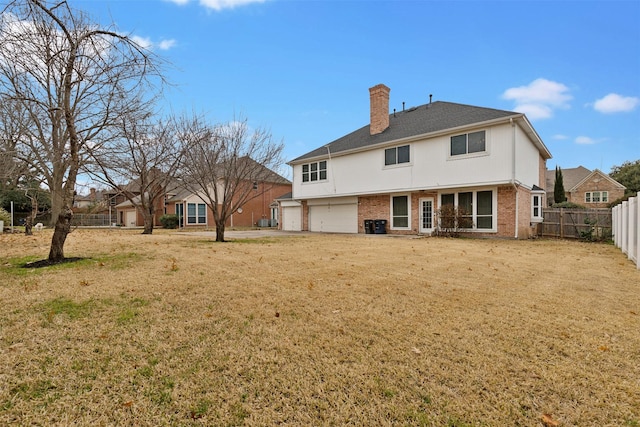 back of property featuring a yard and a garage