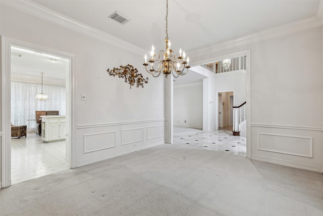 spare room featuring crown molding, light colored carpet, and an inviting chandelier