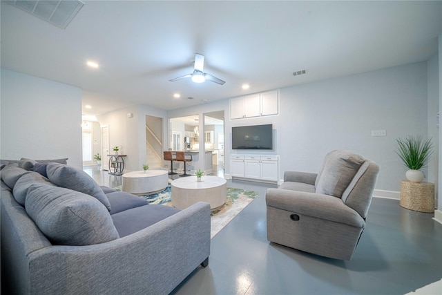 living area featuring recessed lighting, visible vents, finished concrete flooring, and baseboards