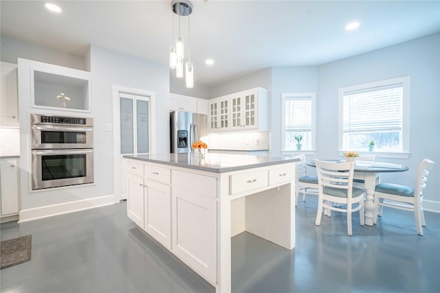 kitchen with glass insert cabinets, appliances with stainless steel finishes, concrete flooring, and recessed lighting