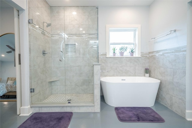 full bath with tile walls, a freestanding tub, a shower stall, and ensuite bathroom