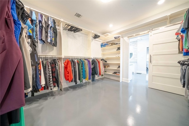 spacious closet with a barn door and visible vents