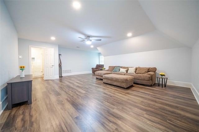 living room featuring ceiling fan, visible vents, baseboards, vaulted ceiling, and dark wood finished floors