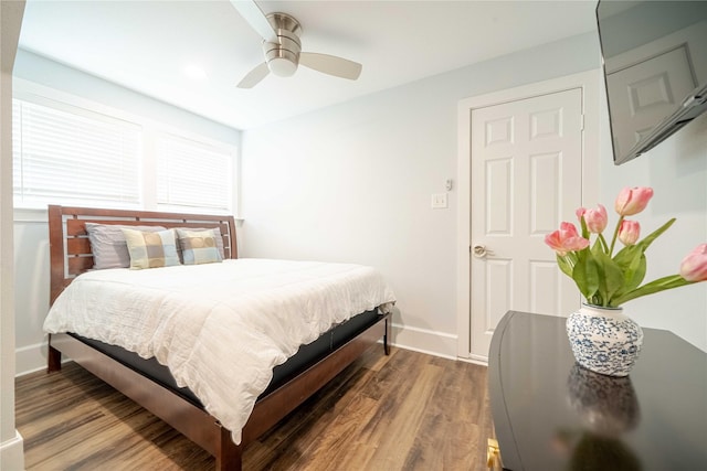 bedroom with ceiling fan, baseboards, and wood finished floors