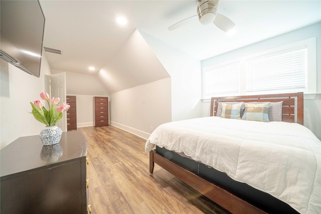 bedroom featuring light wood-style floors, vaulted ceiling, baseboards, and a ceiling fan