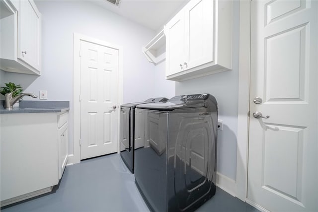 washroom with cabinet space, visible vents, and washing machine and clothes dryer