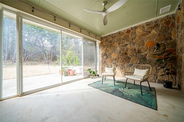 unfurnished sunroom with ceiling fan, lofted ceiling, and visible vents