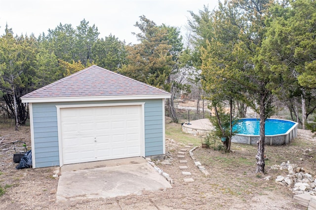 detached garage featuring a fenced in pool