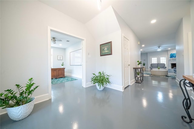 corridor with finished concrete floors, recessed lighting, and baseboards