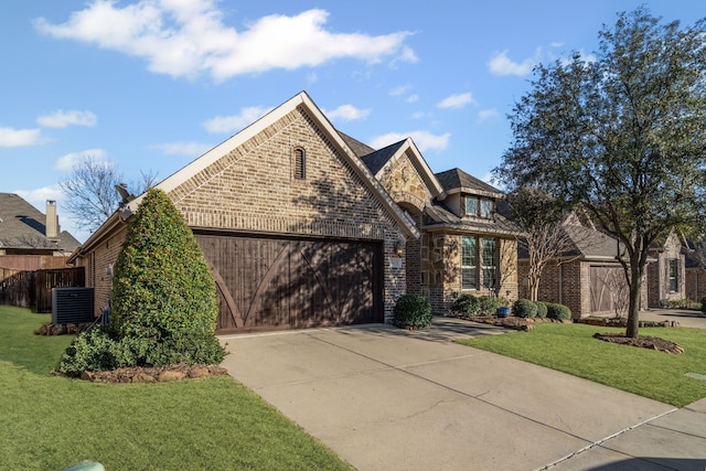 view of front of house featuring a garage, a front yard, and central air condition unit