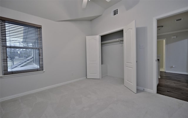 unfurnished bedroom with ceiling fan, a closet, and light carpet