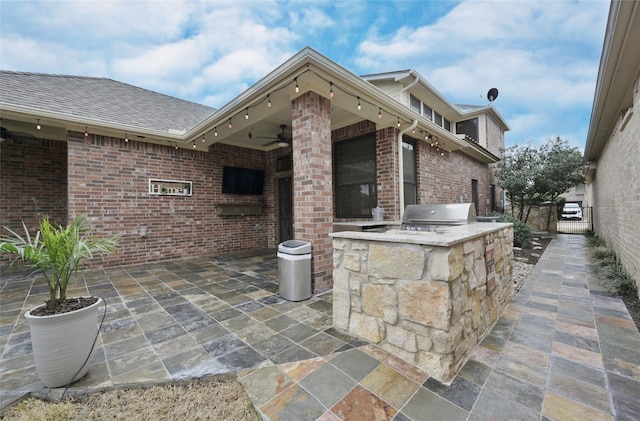 view of patio featuring ceiling fan, a grill, and exterior kitchen