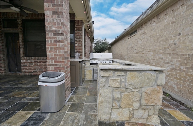 view of patio / terrace with exterior kitchen, area for grilling, and ceiling fan