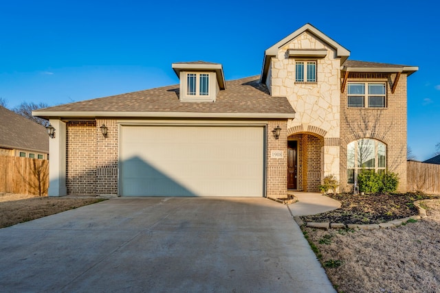 view of front of house featuring driveway, stone siding, an attached garage, fence, and brick siding