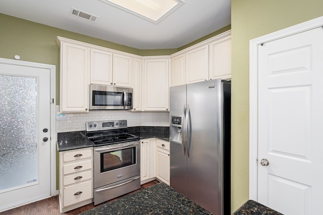 kitchen with white cabinetry, backsplash, and stainless steel appliances