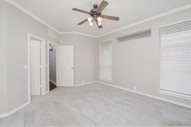 unfurnished bedroom featuring crown molding, light colored carpet, and ceiling fan