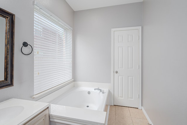 bathroom featuring tile patterned flooring, vanity, a bathtub, and a healthy amount of sunlight