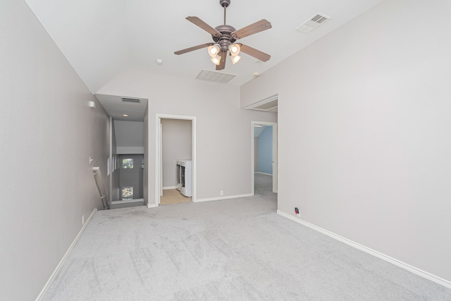 unfurnished bedroom featuring washer / dryer, light colored carpet, lofted ceiling, and ceiling fan