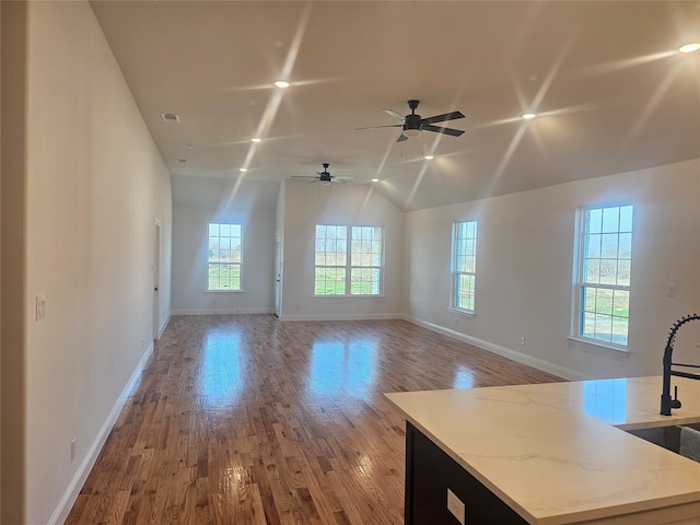 interior space featuring lofted ceiling, sink, and light hardwood / wood-style floors