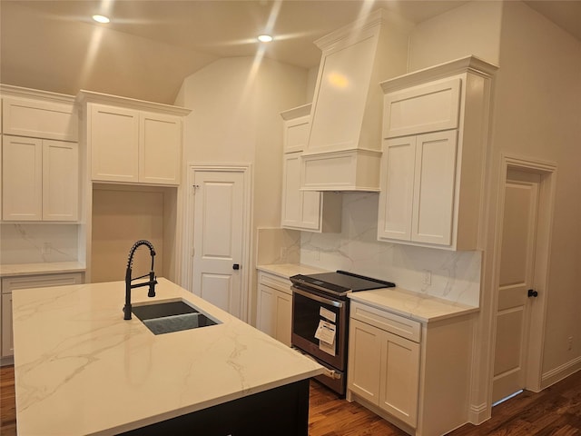 kitchen featuring sink, a center island with sink, wall chimney exhaust hood, and electric stove