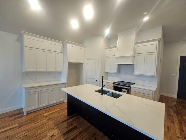 kitchen with electric stove, white cabinetry, an island with sink, and premium range hood