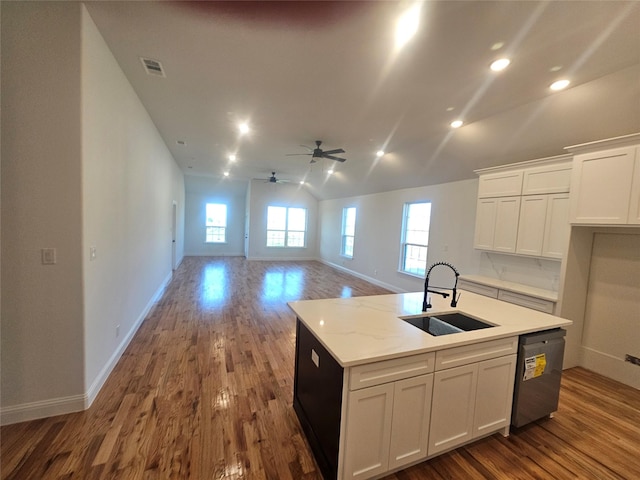 kitchen featuring dark wood-type flooring, sink, white cabinetry, stainless steel dishwasher, and a kitchen island with sink