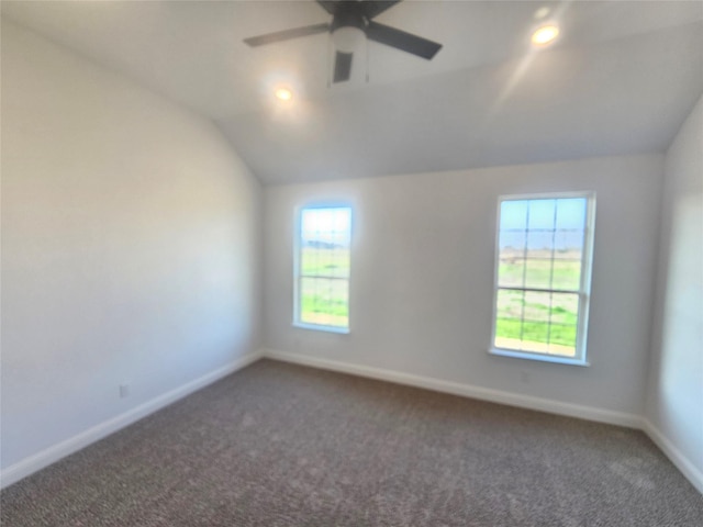 carpeted spare room featuring vaulted ceiling, ceiling fan, and plenty of natural light