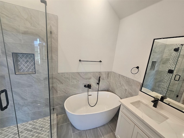 bathroom featuring vanity, independent shower and bath, and tile walls