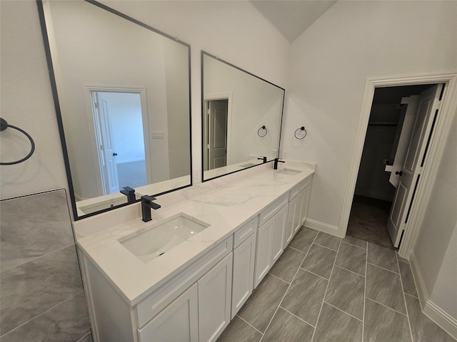 bathroom featuring vanity and lofted ceiling