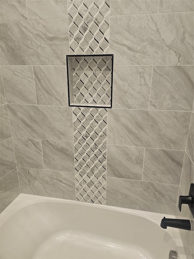 bathroom featuring tiled shower / bath