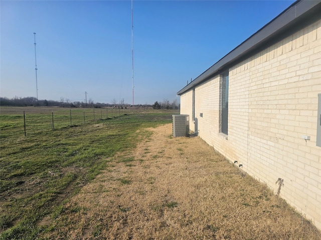 view of yard with central AC unit and a rural view