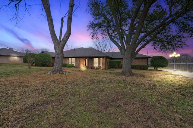 ranch-style home featuring a lawn