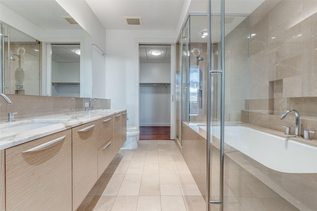 full bathroom featuring toilet, vanity, plus walk in shower, tile patterned flooring, and backsplash