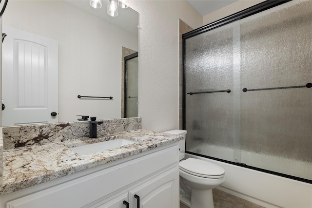 full bathroom featuring toilet, vanity, shower / bath combination with glass door, and tile patterned flooring