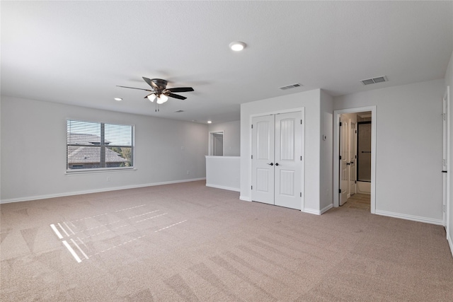 unfurnished room featuring ceiling fan and light colored carpet