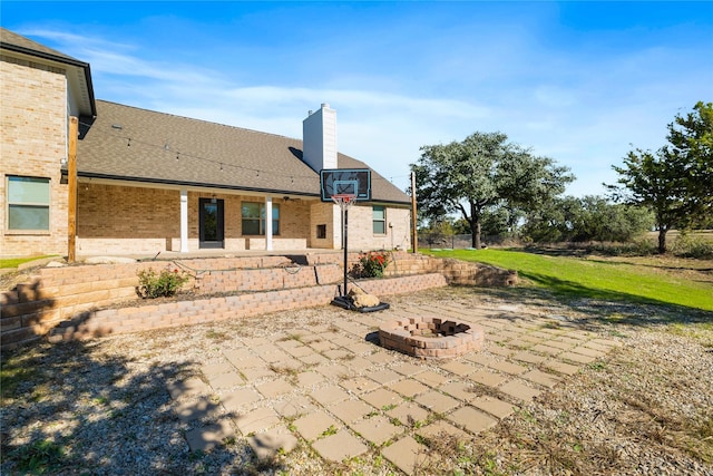 rear view of house featuring an outdoor fire pit and a patio area